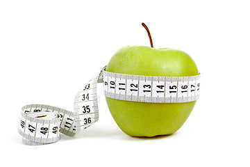 Image showing green apple with a measuring tape and heart symbol isolated