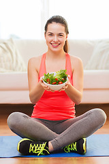 Image showing smiling teenage girl with green salad at home