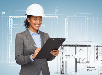 Image showing businesswoman in white helmet with clipboard