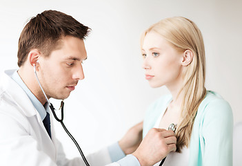 Image showing doctor with stethoscope listening to the patient