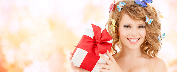 Image showing teenager with butterflies in hair showing present