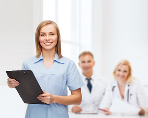 Image showing smiling female doctor or nurse with clipboard