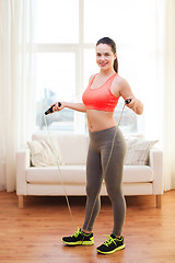 Image showing smiling teenage girl with skipping rope at home