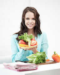 Image showing beautiful woman in the kitchen cutting vegetables