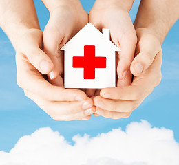 Image showing hands holding paper house with red cross