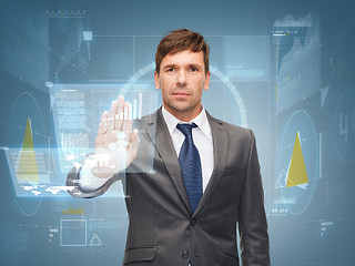 Image showing attractive buisnessman wotking with virtual screen