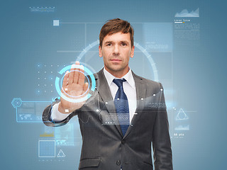 Image showing attractive buisnessman wotking with virtual screen