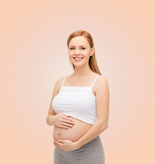 Image showing happy future mother touching her belly