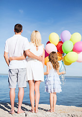 Image showing happy family at the seaside with bunch of balloons