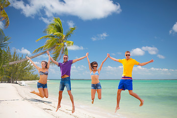 Image showing group of friends or couples jumping on the beach