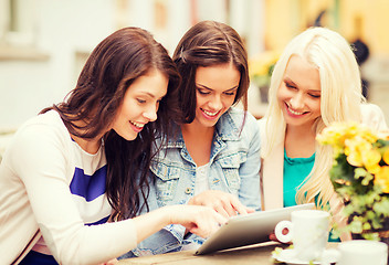 Image showing beautiful girls looking at tablet pc in cafe