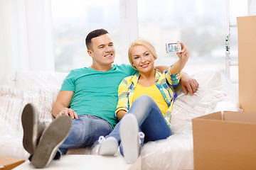 Image showing smiling couple relaxing on sofa in new home