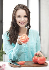 Image showing beautiful woman in the kitchen cutting vegetables