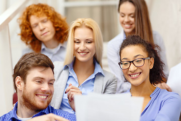 Image showing team with papers and take away coffee on staircase