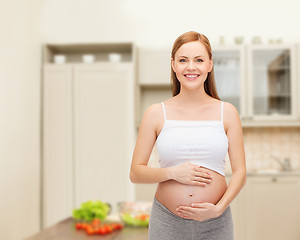 Image showing happy future mother touching her belly