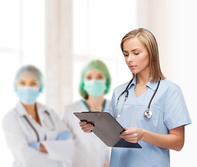 Image showing smiling female doctor or nurse with clipboard