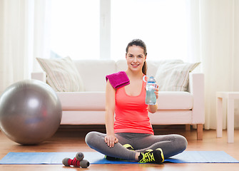 Image showing smiling girl with bottle of water after exercising