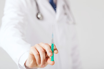 Image showing male hand holding syringe with injection