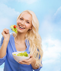 Image showing smiling young woman with green salad