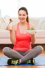 Image showing smiling teenage girl with green salad at home