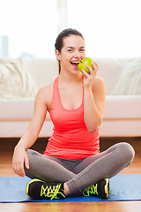 Image showing smiling teenage girl with green apple at home