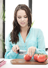 Image showing beautiful woman in the kitchen cutting vegetables