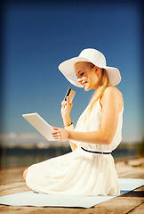 Image showing woman in hat doing online shopping outdoors