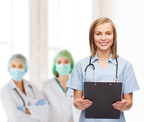 Image showing smiling female doctor or nurse with clipboard