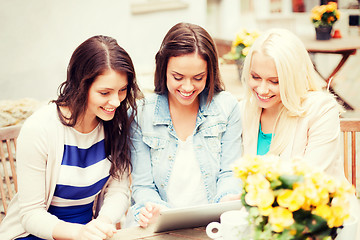 Image showing beautiful girls looking at tablet pc in cafe