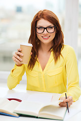 Image showing smiling student girl reading books in library