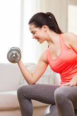 Image showing smiling girl exercising with dumbbells