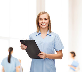 Image showing smiling female doctor or nurse with clipboard