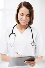 Image showing doctor with stethoscope writing prescription