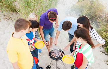 Image showing group of friends having picnic and making barbecue