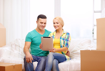Image showing couple relaxing on sofa with tablet pc in new home