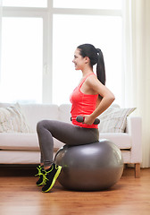 Image showing smiling girl exercising with fitness ball