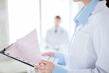 Image showing female holding clipboard with cardiogram