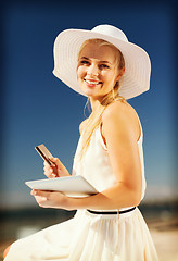 Image showing woman in hat doing online shopping outdoors