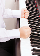 Image showing close up of child hands in fists hitting the piano