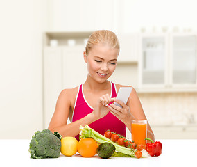 Image showing woman with vegetables pointing at smartphone