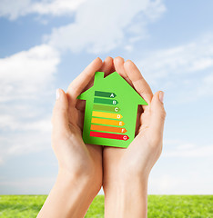 Image showing hands holding green paper house