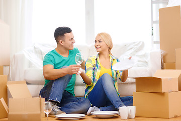 Image showing smiling couple unpaking boxes with kitchenware