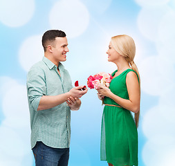 Image showing smiling couple with flower bouquet and ring