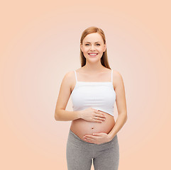 Image showing happy future mother touching her belly