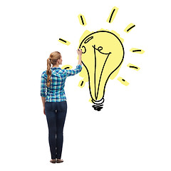 Image showing woman from the back drawing light bulb in the air