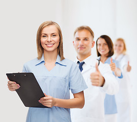 Image showing smiling female doctor or nurse with clipboard