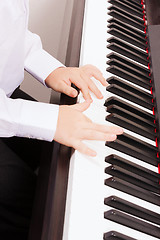 Image showing close up of child hands playing the piano