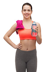 Image showing sporty woman with towel and water bottle