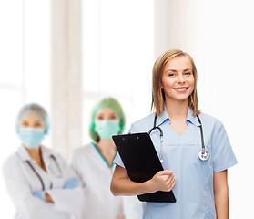 Image showing smiling female doctor or nurse with clipboard