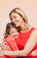 Image showing smiling mother and daughter hugging